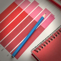 Market Research Chart with Colored Pencils and Notebook Market research chart with red and pink bars, blue pencil, and red notebook