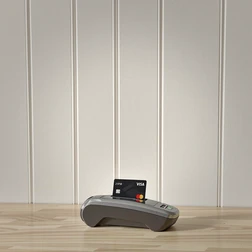 Card Payment Terminal on Wooden Surface Card payment terminal with a credit card on a light wooden surface.